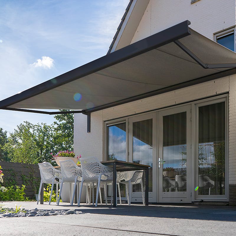 Oviedo terrassmarkis med matt svart stativ och utfällt solskydd över altan.